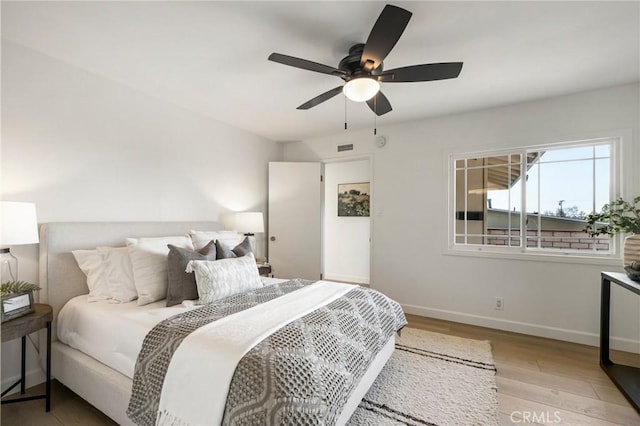 bedroom with ceiling fan and light hardwood / wood-style floors