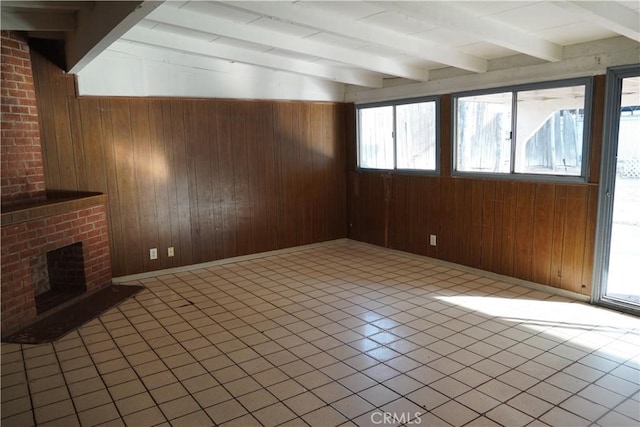 unfurnished living room featuring a fireplace, light tile patterned floors, beamed ceiling, and wooden walls