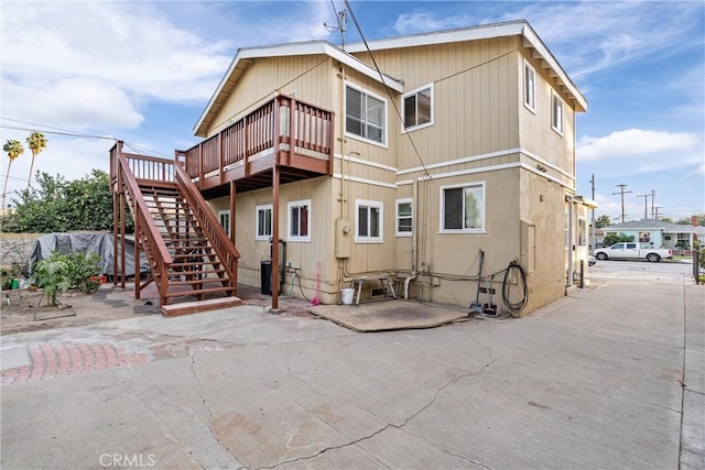 rear view of property featuring a patio area and a wooden deck