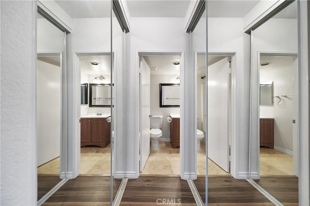 bathroom with hardwood / wood-style flooring, vanity, and toilet