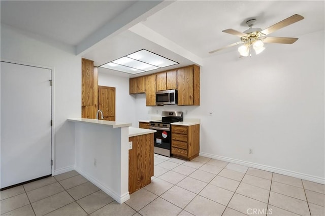 kitchen with sink, light tile patterned floors, kitchen peninsula, ceiling fan, and stainless steel appliances