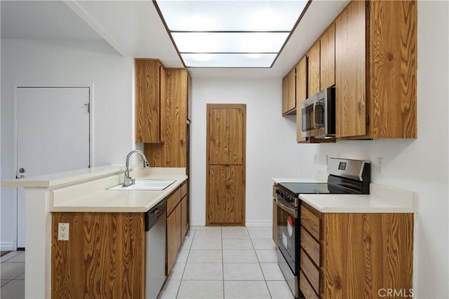 kitchen with stainless steel appliances, sink, and light tile patterned floors