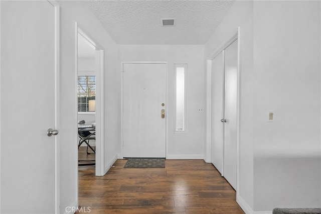 entrance foyer with a textured ceiling and dark hardwood / wood-style flooring