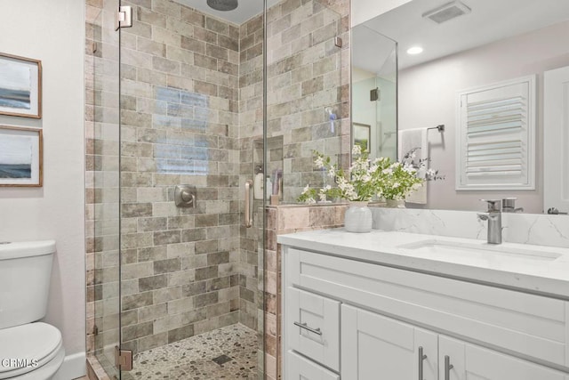 bathroom featuring toilet, an enclosed shower, and vanity