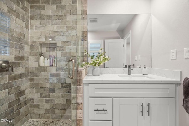 bathroom with a shower with shower door and vanity