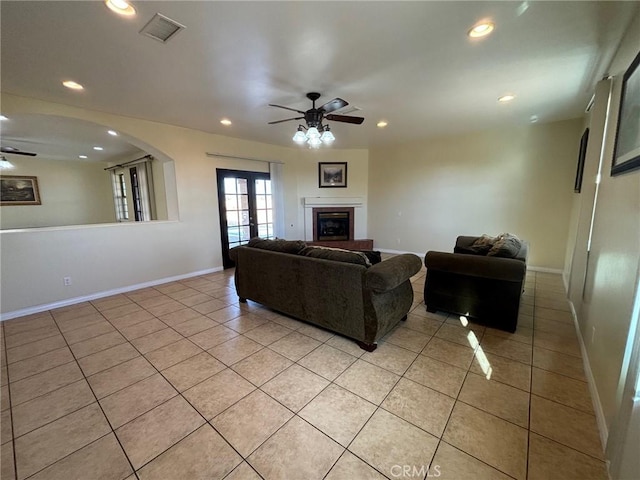 tiled living room with ceiling fan and french doors