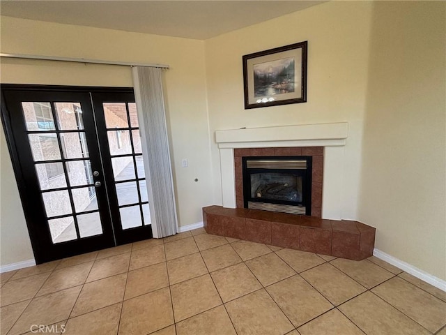 unfurnished living room featuring a tiled fireplace, light tile patterned floors, and french doors