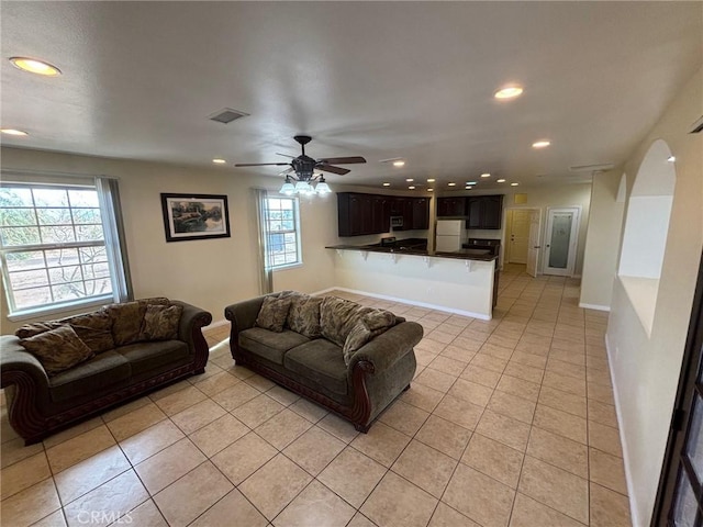 tiled living room with ceiling fan and plenty of natural light