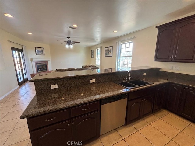 kitchen featuring light tile patterned floors, kitchen peninsula, dishwasher, and sink