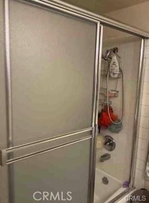 bathroom featuring bath / shower combo with glass door