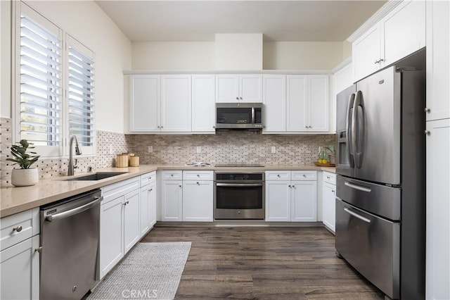 kitchen featuring stainless steel appliances, white cabinetry, and sink