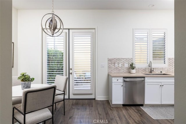 kitchen with pendant lighting, white cabinets, dishwasher, sink, and backsplash