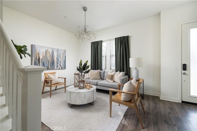 living room with dark wood-type flooring, a wealth of natural light, and a chandelier