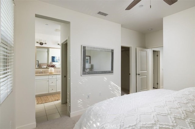 bedroom with ensuite bath, sink, ceiling fan, and light carpet