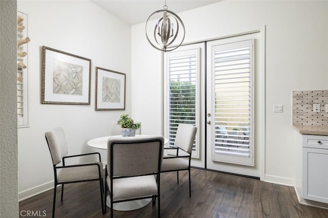 dining space with dark hardwood / wood-style floors and an inviting chandelier