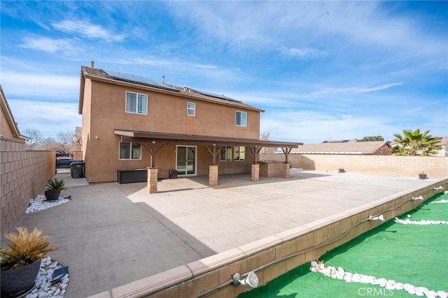 back of property featuring solar panels and a patio