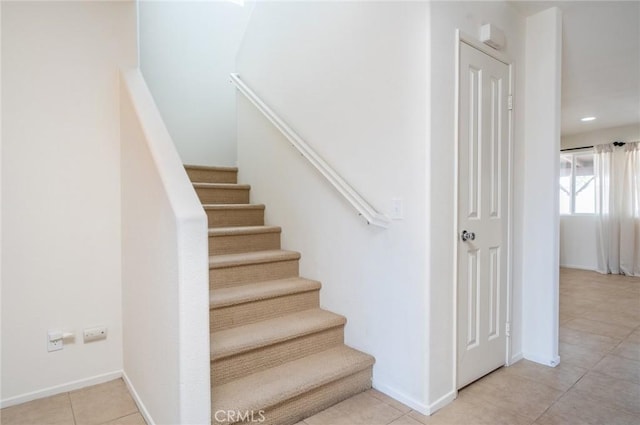 stairway with tile patterned floors