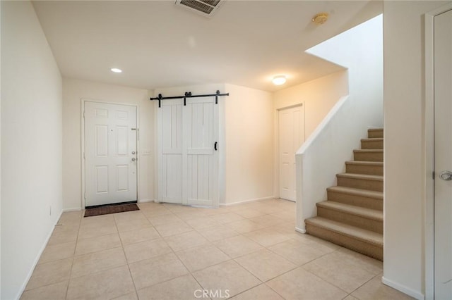 tiled entryway featuring a barn door