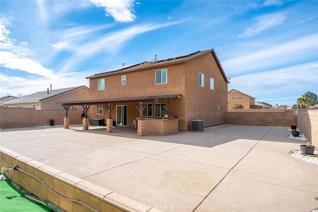 rear view of property featuring cooling unit, an outdoor kitchen, and a patio