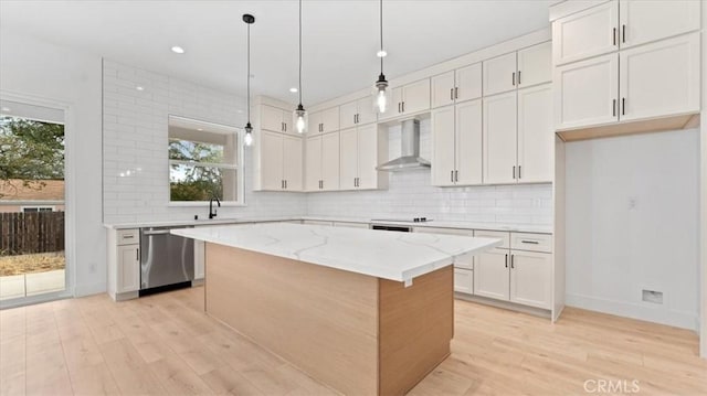 kitchen with white cabinets, dishwasher, wall chimney exhaust hood, and a kitchen island