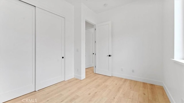 unfurnished bedroom featuring a closet and light hardwood / wood-style floors