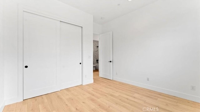 unfurnished bedroom featuring a closet and light wood-type flooring