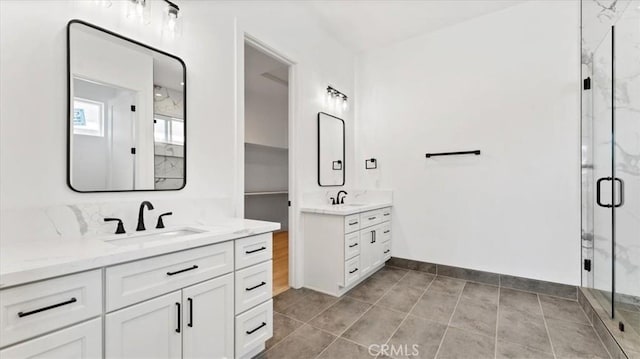 bathroom with a shower with shower door, tile patterned floors, and vanity