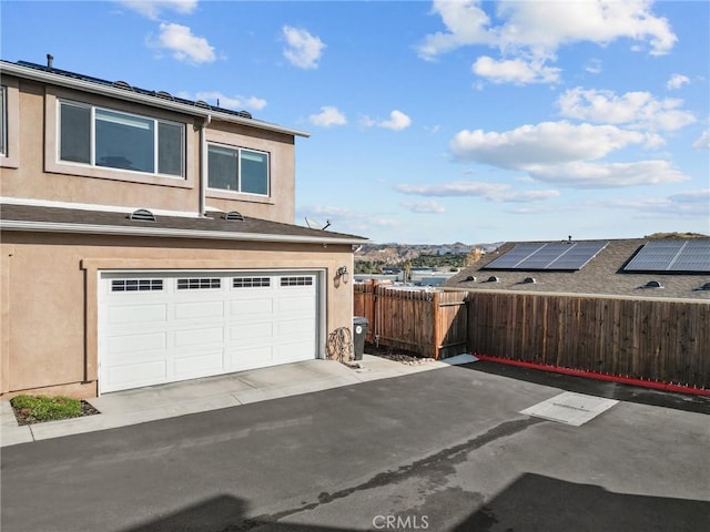 view of side of property with a garage and solar panels