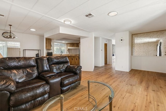 living area featuring light wood-style floors and visible vents