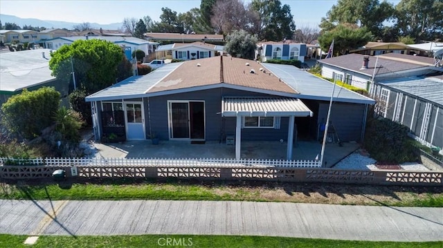 rear view of house featuring a patio area, a residential view, fence, and a sunroom