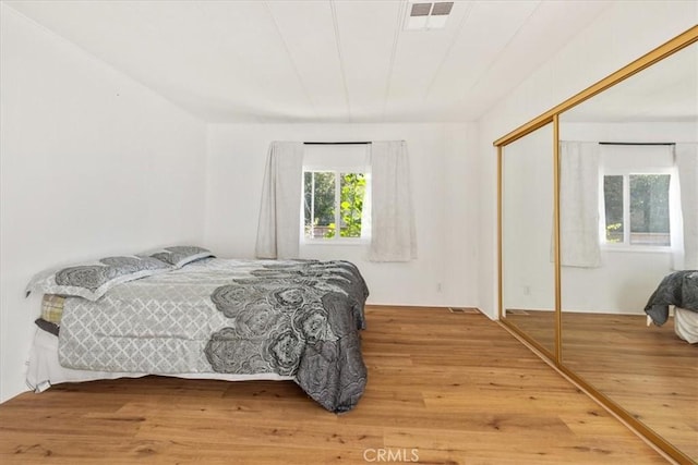 bedroom featuring a closet, wood finished floors, and visible vents