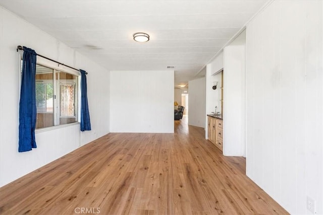 empty room featuring light wood-style floors and visible vents