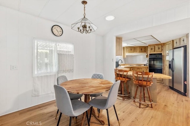 dining room featuring light wood-style floors and a notable chandelier