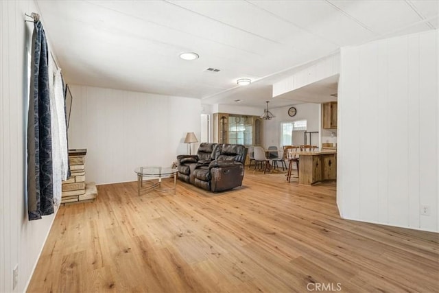 living room with light wood-style flooring and visible vents