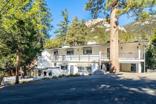 view of front of property with a balcony and a mountain view