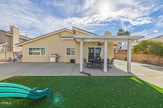 rear view of house with ceiling fan and a patio