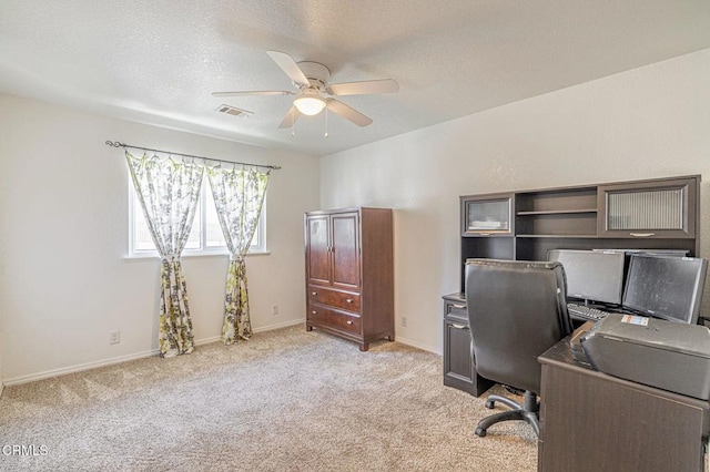 carpeted office space with ceiling fan and a textured ceiling