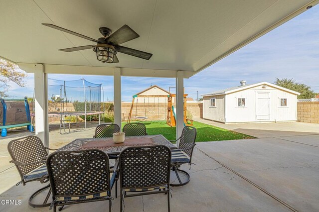 view of patio featuring a trampoline, a storage unit, and a playground