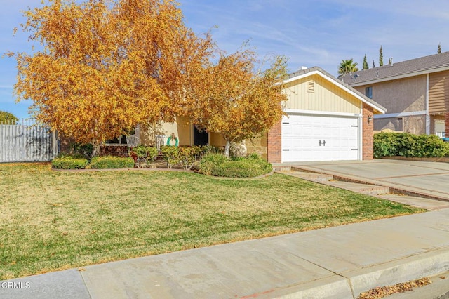 view of property hidden behind natural elements with brick siding, an attached garage, fence, a front yard, and driveway