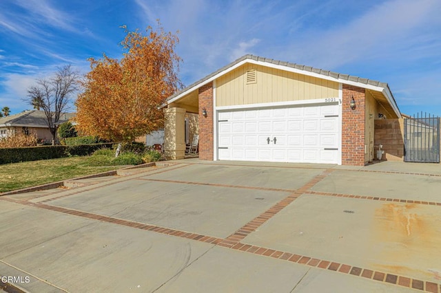 view of property exterior with a garage, brick siding, and driveway