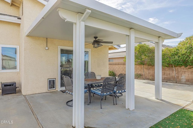 view of patio with a ceiling fan, outdoor dining area, and fence