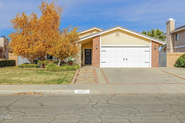 view of front of property featuring brick siding, concrete driveway, a garage, and fence