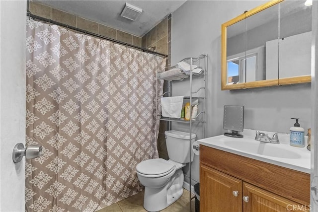 bathroom featuring toilet, vanity, and tile patterned flooring