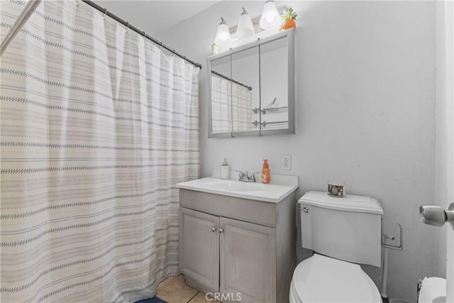 bathroom with toilet, vanity, tile patterned floors, and walk in shower