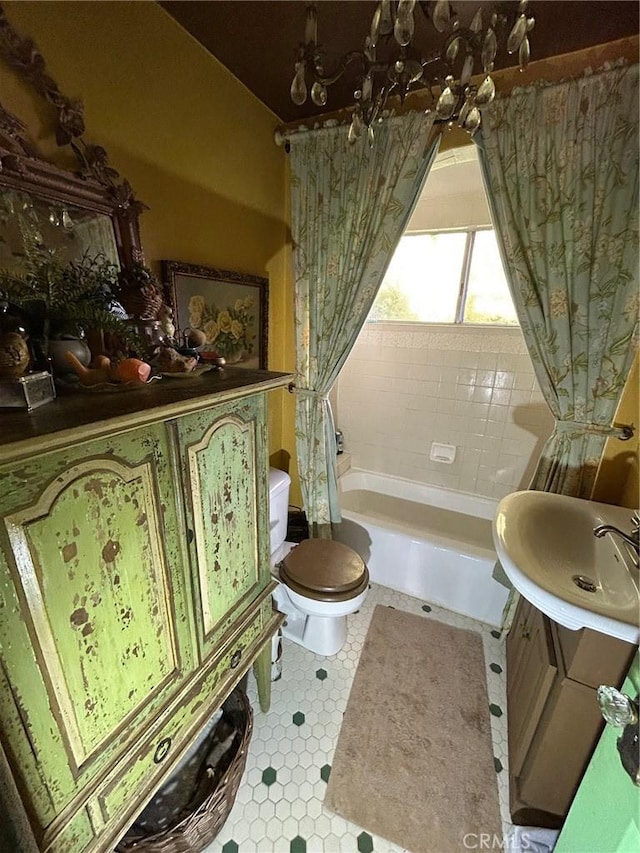 bathroom with tile patterned floors, toilet, vanity, and a bathing tub