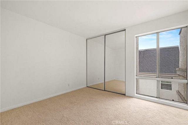 unfurnished bedroom featuring a closet and light carpet