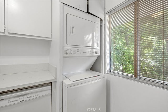 laundry area featuring cabinets and stacked washer and dryer