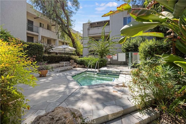 view of swimming pool featuring a patio area and a hot tub