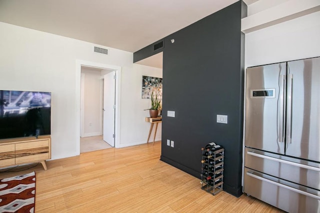 kitchen with stainless steel built in fridge and light wood-type flooring