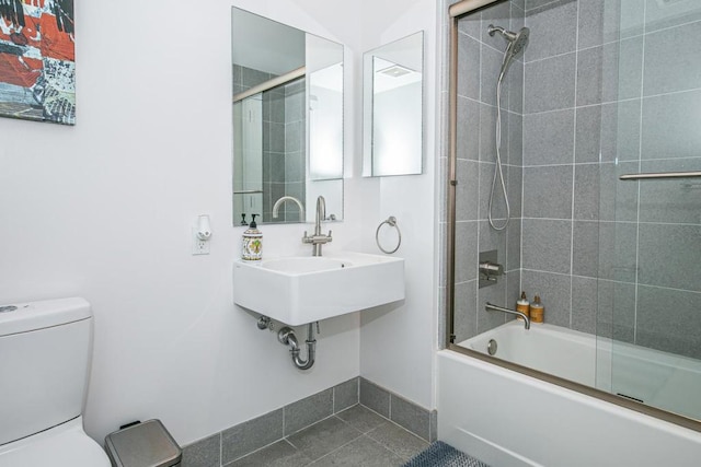 full bathroom featuring tile patterned flooring, toilet, enclosed tub / shower combo, and sink